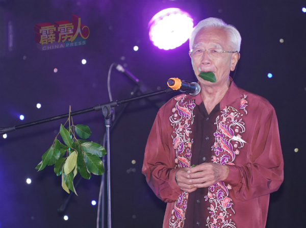 卢源禄口含叶子,表演绝活,吹起耳熟能详的“上海滩”及“平安夜”曲,也带动了现场观众一起拍手和音。