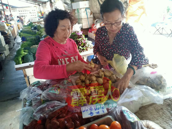 一些市民在菜市场选购慈菇以製为年饰，迎接新年的到来。