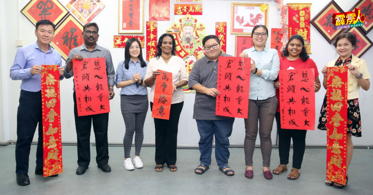 古納瑟加蘭（左2）與本報高級廣告員劉福年（左起）、霹靂州採訪主任梁愛然、中委莎拉絲華蒂、陳楷祥、張玉珊、丹娜及廣告部同事鄭碧容，各持春聯祝各界新年快樂，萬事如意。