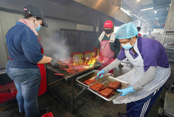 工友忙着烧烤肉干，并将烧好肉干取走准备包装应市。