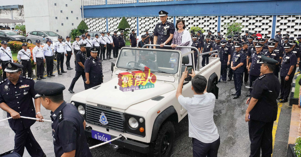 林鸿选与妻子李美霞在众警官护航下,离开霹雳州警察总部。