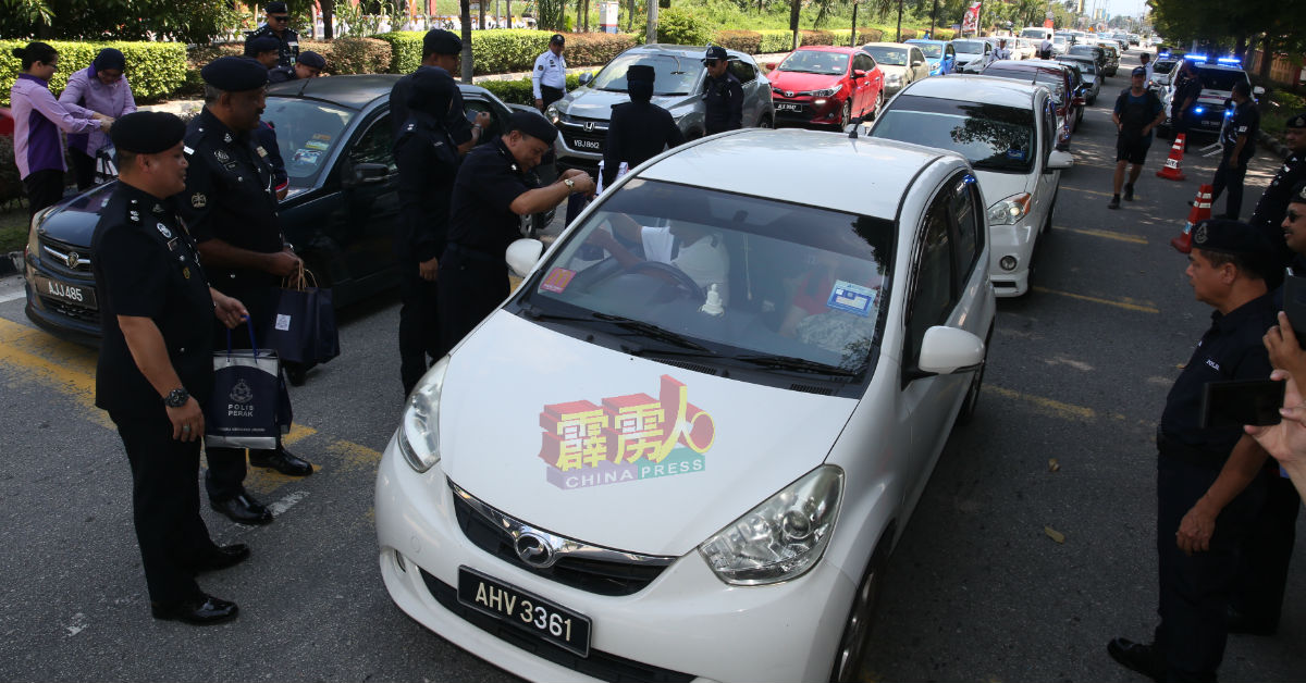 警方会见道路使用者,派发礼袋给驾驶人士。