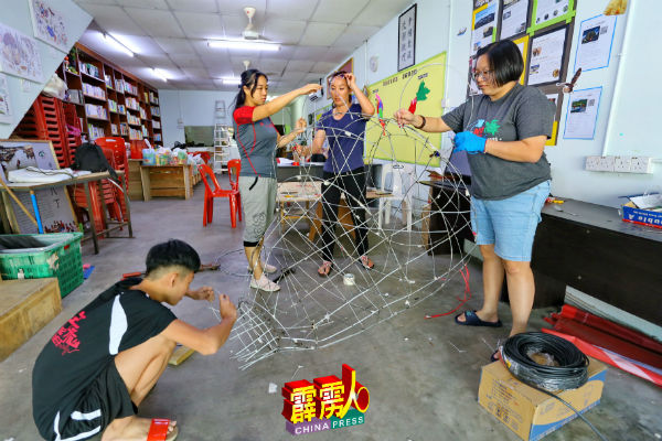 工作人员忙碌赶制13呎高金鼠造型彩灯,希望赶得及亮灯日完工,右起蔡依霖助理王菱翠、黄嫒春及吴恬盈。