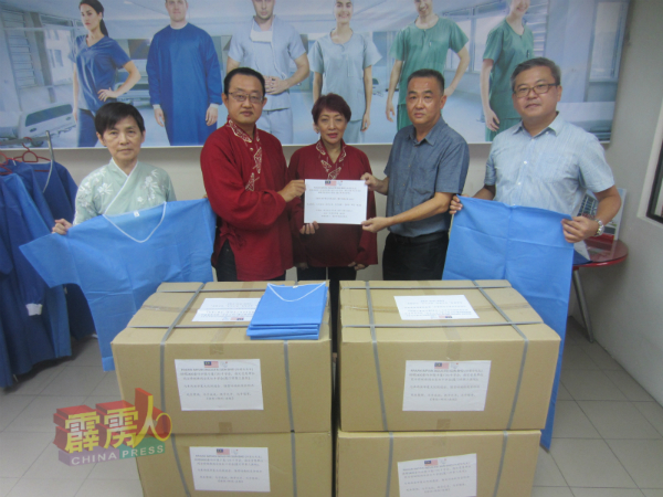 郑建伦（右2）捐出2400套一次性手术服给中国，并将物资移交给陈沛（左2），由陈美容（中）、关名洙（左）及钟培志（右）见证。
