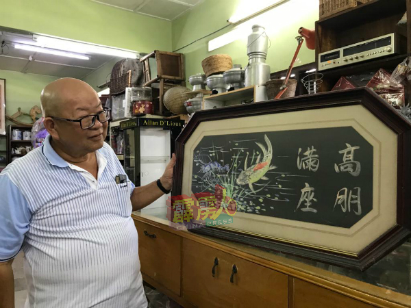陈福贤向记者展示一幅早年餐馆在新张营业时常用以祝贺的字画,如今也是非常少见。