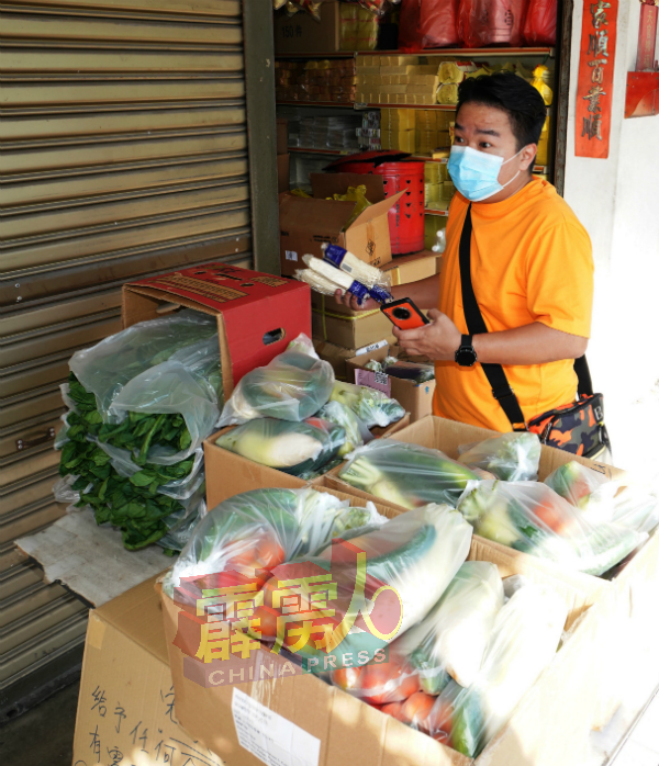 江奕龙在准备300包蔬菜派发给市民。