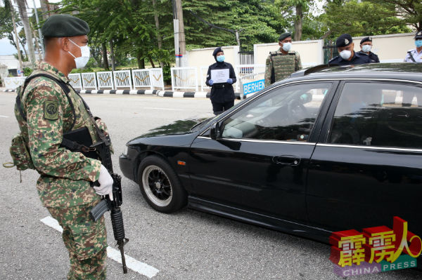 军人荷枪实弹配合警员执勤。