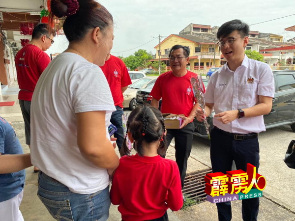 郑传毅(右)派送玫瑰花给民众,共庆妇女节。