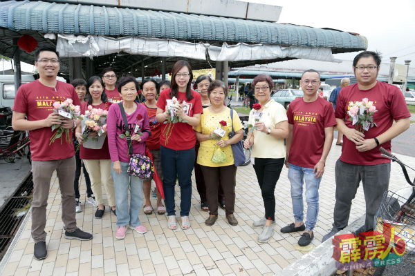 崔慈恩（前右5）为妇女送上玫瑰及祝福，右起为黄家杰、李斯豪及李羿昊（左）。