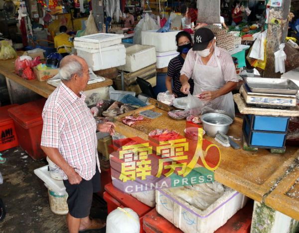 小贩提升卫生意识,戴上口罩销售食材。