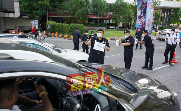 .警方展示印有劝导式字眼的纸张,呼吁民众留在住家。