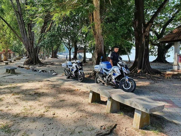 一名警员在霹雳州曼绒直落峇迪海边处喂流浪猫时,也安排猫咪遵循一公尺的社交距离。