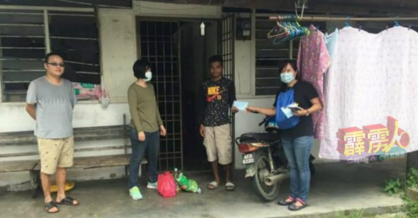 周子豪（左起）、曾俏仪、与廖仪玲（右）送米粮及口罩给居住在务边瓦屋仔的原住民（右2）。