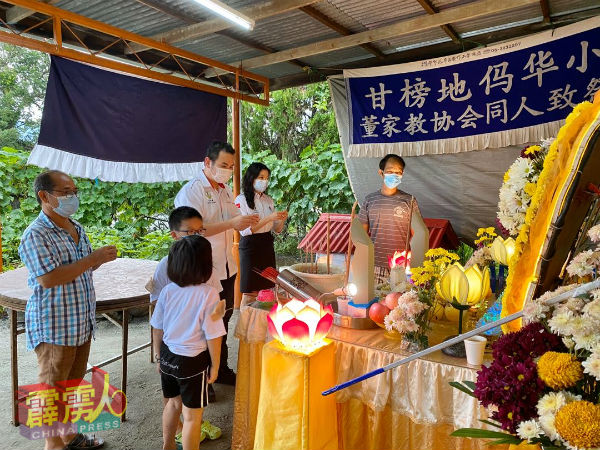 古海燕（右2起）、张哲敏和锺启明（左）为死者上香鞠躬，右起为邹耀祥与其9岁（左2起）和7岁的儿女。