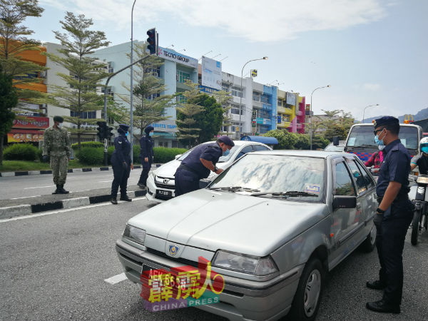 阿斯玛迪（左）今日巡视美丹务边路障检查站时，向民众询问究竟要前去何处。