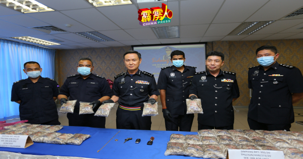 吴文恭(左3)展示警方在一起行动中起获的毒品海洛因,右2为 李庆泉,左2为奥斯曼。