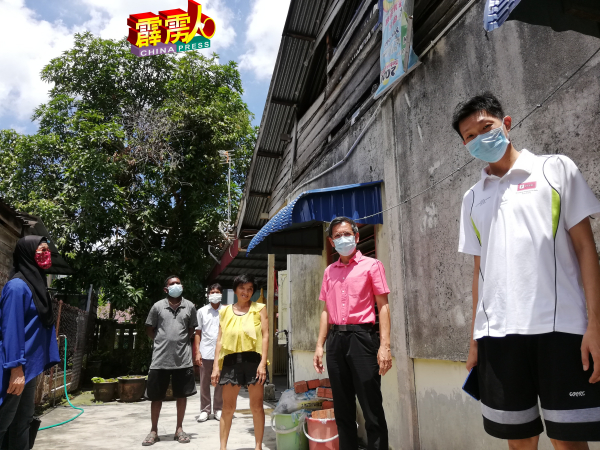 廖泰义(右2)巡视板屋破损情况,应允协助住户紧急维修。
