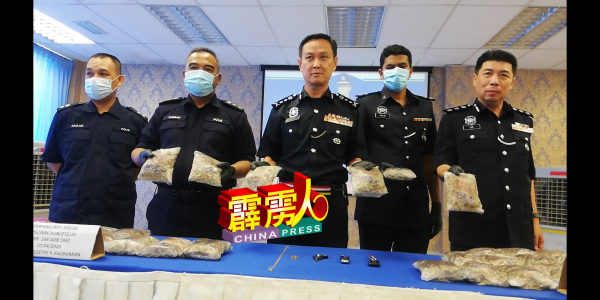 吴文恭(左3)展示警方在一起行动中起获的毒品海洛因,右2为 李庆泉,左2为奥斯曼。