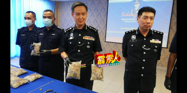 吴文恭（右2）展示警方起获的海洛因，右为李庆泉。