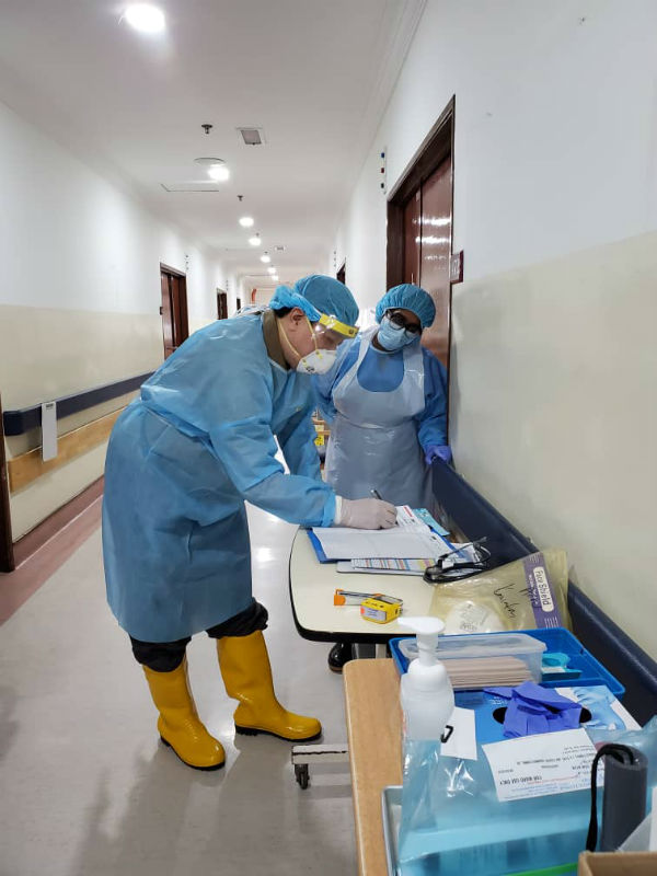 黄仲贤穿上一次性防护衣、水鞋、戴上头帽及口罩后，才进入隔离病房，以防万一。