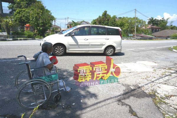 老翁在大路旁行乞险像环生,令人捏一把冷汗。