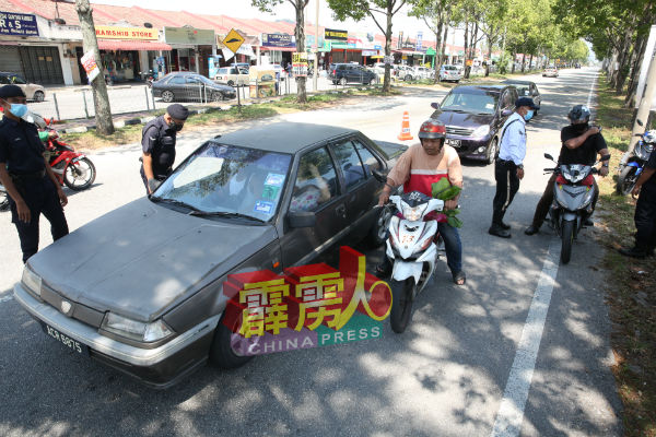 警方在巴占再也花园路口前的捷径进行路检。