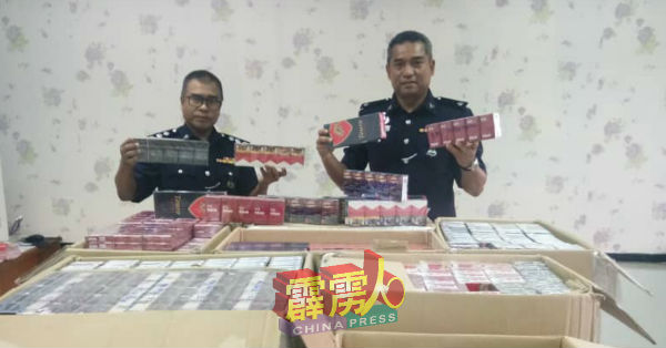 阿斯哈利(右)展示起获的漏税烟。