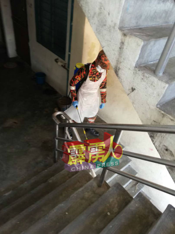 消拯员在楼梯周遭，进行消毒。