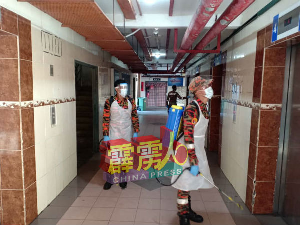 消拯员乘搭电梯，到高楼层组屋进行消毒工作。