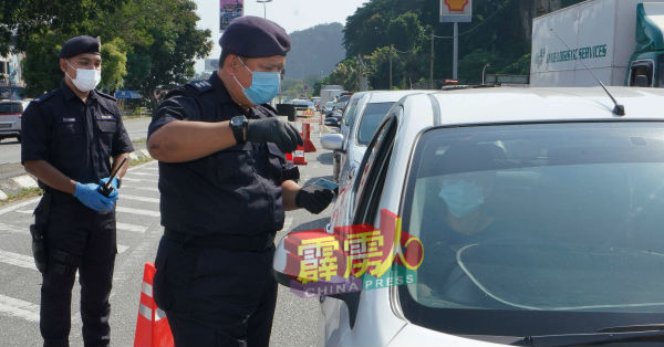 阿斯马迪(右起)在哈斯尼陪同下,检查途经路检的驾驶者大马卡。