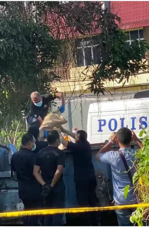 数名警员正谨慎地从垃圾桶里取出炸弹，并以麻布包裹载走。
