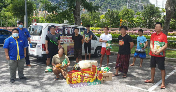 黄美圆(左起)及莫少荣派送粮食给印尼外劳。
