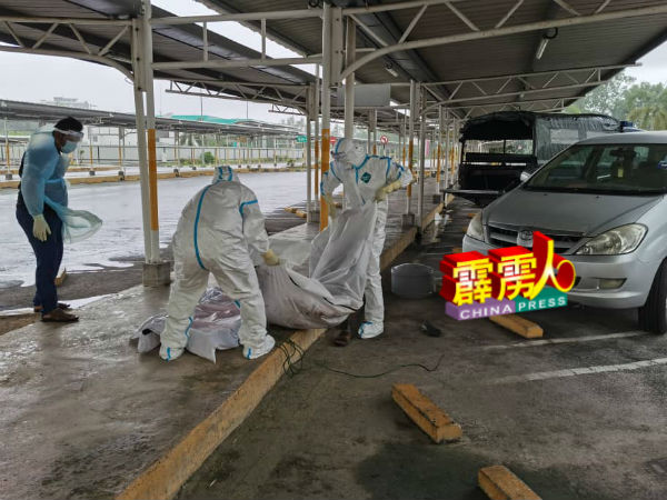 卫生局人员以防疫标准作业程序，处理死者尸体。