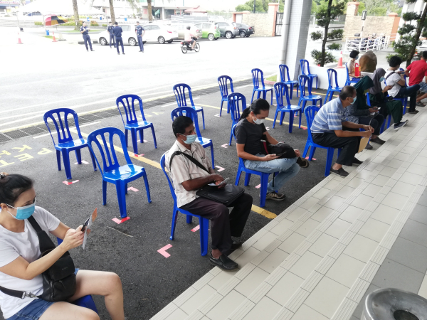 民众等候期间坐着的椅子,也保持社交距离的间隔。