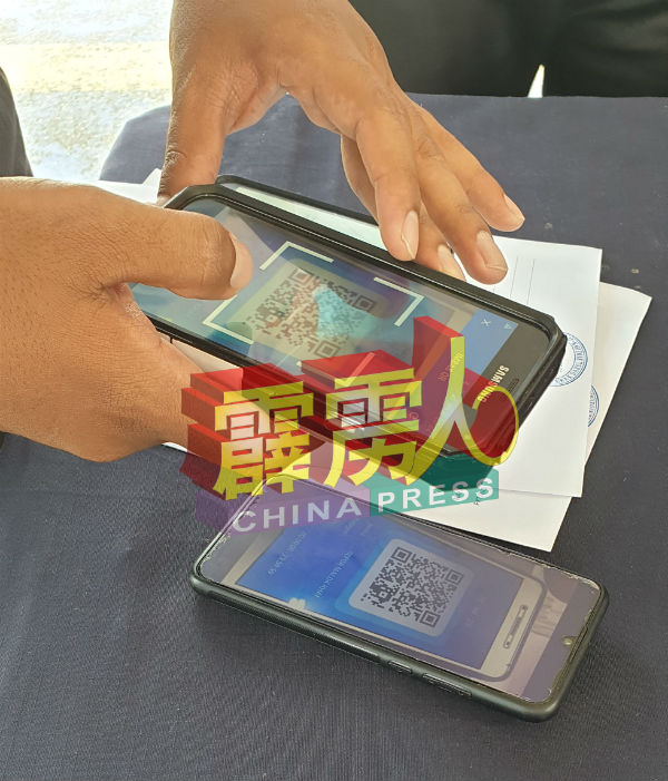 警察使用流动接收手机应用程式，检查民众通过手机应用程式申请的二维条码。