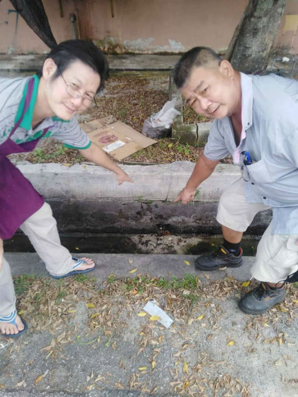 李师辉(左起)与林汉茂,指出地下水管爆裂之处。