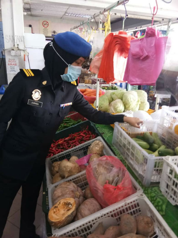 执法官员正在检查蔬果有没有标价。
