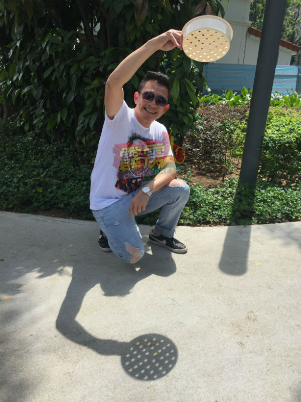 吴进顺手持有小孔的器皿来展示简单的“针孔”投影法。