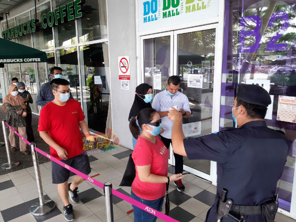 欲进入购物中心“血拚”的民众,须戴口罩,保持社交距离排队及测量体温。