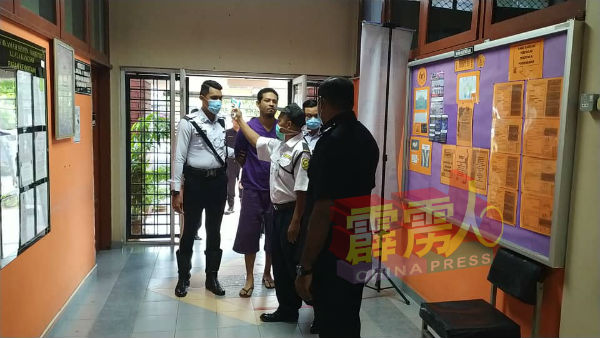 地庭保安为被告与交警检测体温。