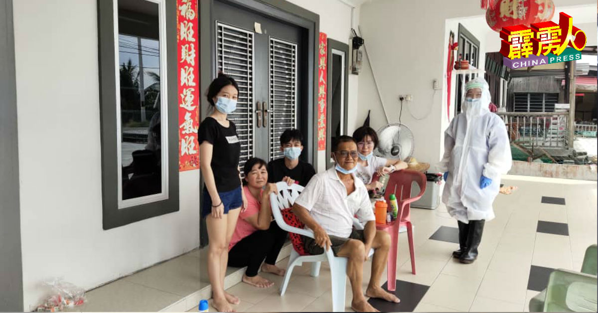 曾慧晶(右)穿着防护服,在医护人员陪同下赶回家乡,见父亲最后一面,并拍下这张“最后的全家福”。