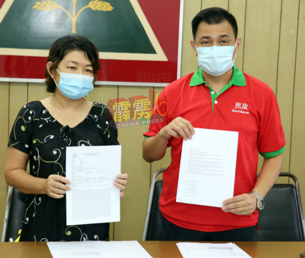 植旷荣(右)与吴太太向媒体出示报案文件。