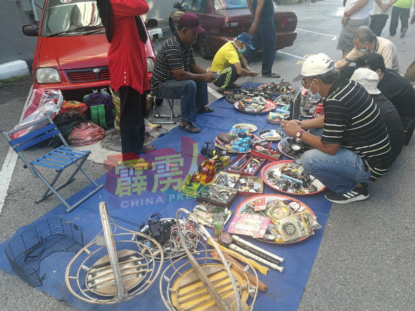 售卖二手钓鱼器材的摊位，吸引民众前来围观及问价。