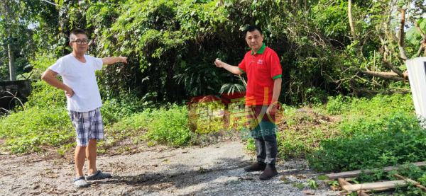 居民黄锦泉（左）向植旷荣投诉打昔英德花园出现局部除草情况。