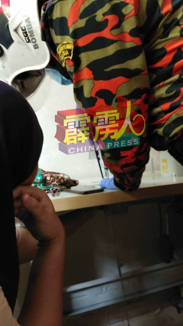 妇女大拇指夹在缝纫机底部。