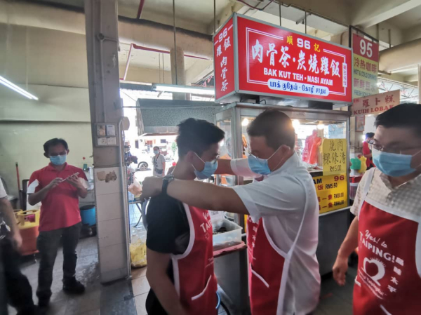 倪可敏為小販圍起圍群，右為鄭國霖。