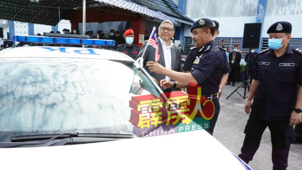 拉扎鲁丁(右2)为本田思域巡逻车挂上国旗;右为黄光顺。