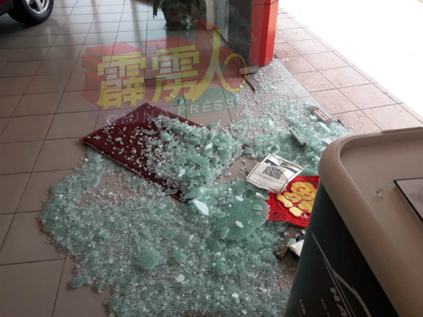 玻璃门被击碎后，地上布满玻璃碎片。