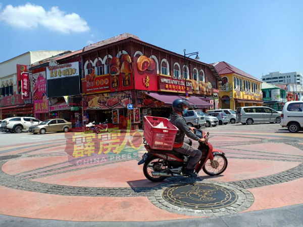 怡保著名土产街在复管令下，游客逐渐回流，一名小贩骑着摩哆忙去办货。
