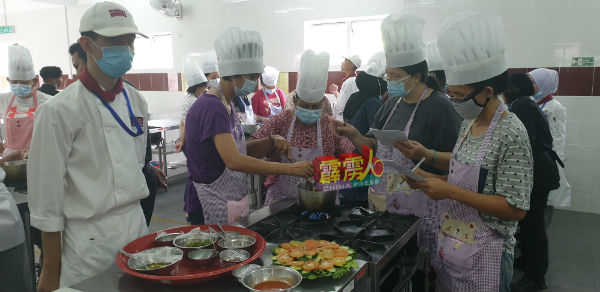 妈妈学习如何烹煮海南鸡饭；右为刘锦燕。